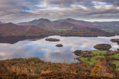 Göl Bölgesi 'ndeki Walla Crag' dan Derwentwater 'ın üzerinden Catbell' lere ve çarpıcı sonbahar renkleriyle uzak dağlara bakan destansı sonbahar manzarası.
