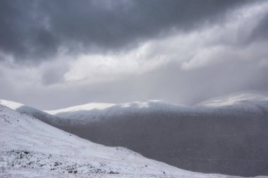 Kar fırtınası sırasında İskoçya 'nın dağlarının tepesinden Rannoch Moor' a kadar uzanan güzel kış manzarası ve yüksek rüzgarlarla dağların tepesinden kayma.