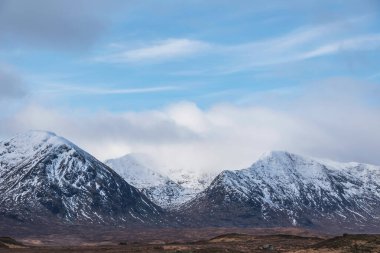 İskoçya 'nın dağlık kesimlerindeki Ba Gölü' nden dramatik bulutlar eşliğinde manzaralı muhteşem bir kış manzarası.