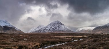 Stob Dearg Buachaille Etive Mor 'un kış manzarası. Rannoch Moor' dan karlı zirvesi ve güzel dramatik bulut oluşumlarıyla izleniyor.