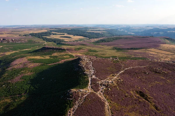 Beautiful late Summer aerial drone landscape image of heather in full bloom in Peak District
