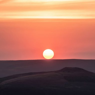 Güneşin batışının Higger Tor 'dan bakıldığında Peak District' te ufku öperkenki görüntüsü.