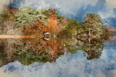 Derwentwater 'daki kayıkhanenin canlı sonbahar gündoğumu sırasında gölün etrafını çevreleyen ormanlık alandaki destansı manzarası.