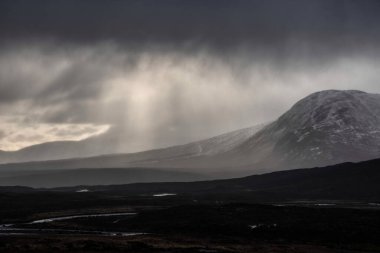 Şiddetli yağış sırasında Rannoch Moor boyunca uzanan çarpıcı kış manzarası manzaraya sisli bir bakış verir.