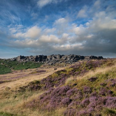 Beautiful landscape image in late Summer of Stanage Edge in Peak District England with stunning clouds formations