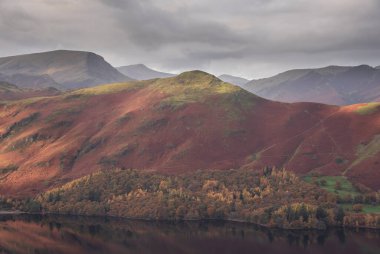Göl Bölgesi 'ndeki Walla Crag' dan Derwentwater 'ın üzerinden Catbell' lere ve çarpıcı sonbahar renkleriyle uzak dağlara bakan destansı sonbahar manzarası.