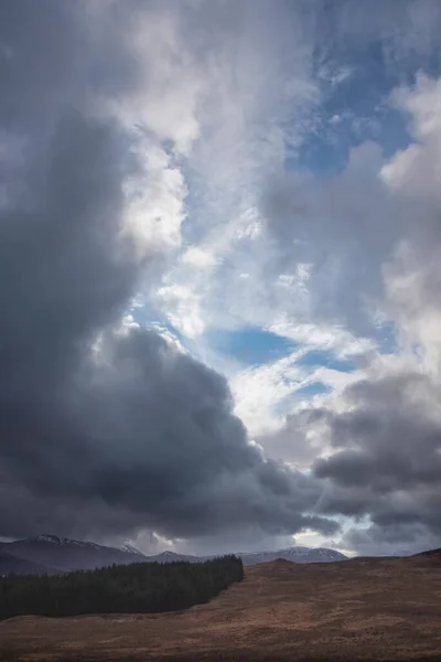 スコティッシュ ハイランドの雪に覆われた山々の上の大きな劇的な嵐の空の風景画像 — ストック写真