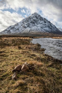 Önplanda Etive Nehri 'nin güzel kış manzarası. Arkaplanda ikonik kar örtülü Stob Dearg Buachaille Etive Mor dağı var.