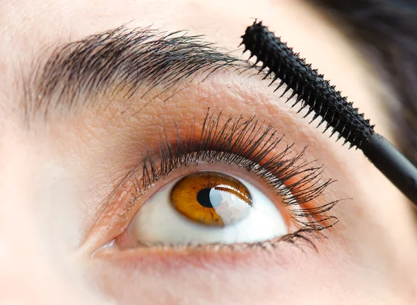 Applying mascara on her eyelashes — Stock Photo, Image