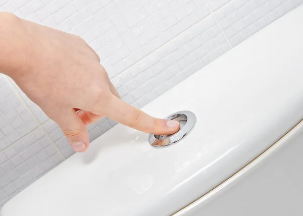 Finger pushing button and flushing toilet — Stock Photo, Image