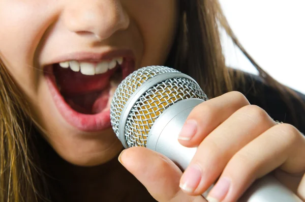 Close up of a girl using a microphone, isolated on a white background. — Stock Photo, Image