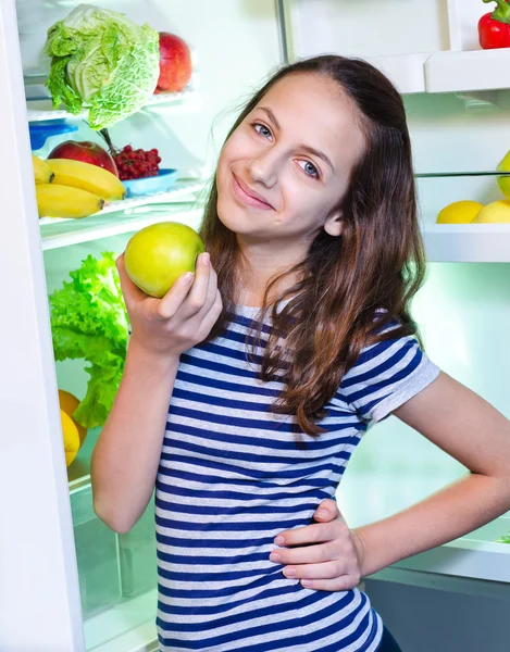 Hermosa chica joven cerca del refrigerador con comida saludable —  Fotos de Stock