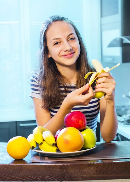 健康食品。美しい若い女性は果物やお菓子の間を選択します。 — ストック写真