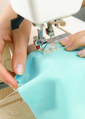 dikiş makinesi üzerinde çalışan bir terzi görüntüsü