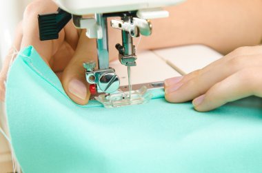 dikiş makinesi üzerinde çalışan bir terzi görüntüsü