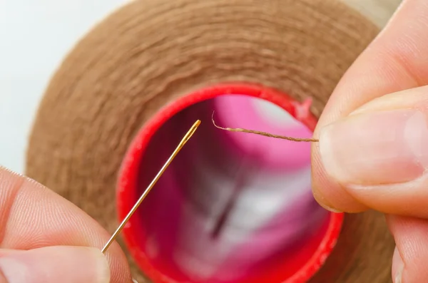 To put the sewing thread into needle — Stock Photo, Image