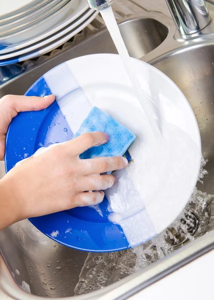 Mani ravvicinate di donna che lava i piatti in cucina — Foto Stock