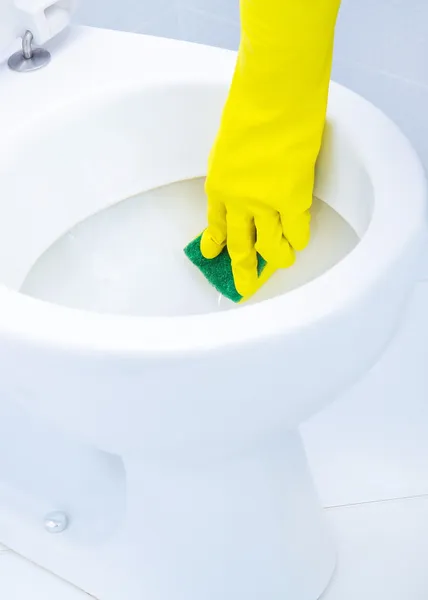 Mani su guanti gialli che puliscono un WC — Foto Stock