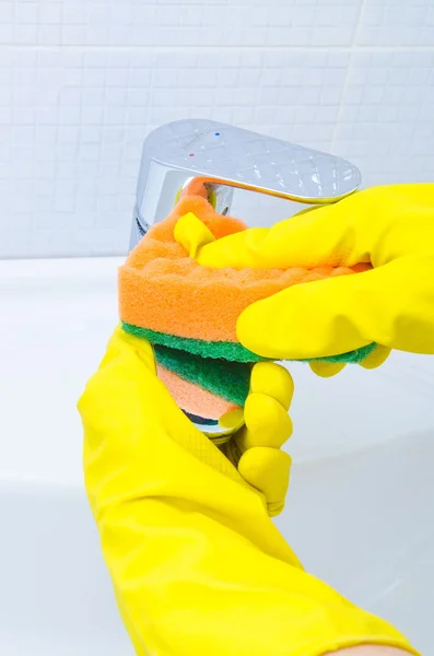 Mujer haciendo tareas en el baño en casa, fregadero de limpieza y grifo con detergente en aerosol — Foto de Stock