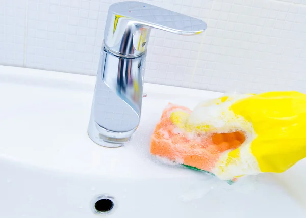 Mujer haciendo tareas en el baño en casa, fregadero de limpieza y grifo con detergente en aerosol —  Fotos de Stock