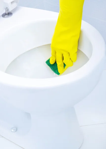 Hands on yellow gloves cleaning a WC Stock Photo