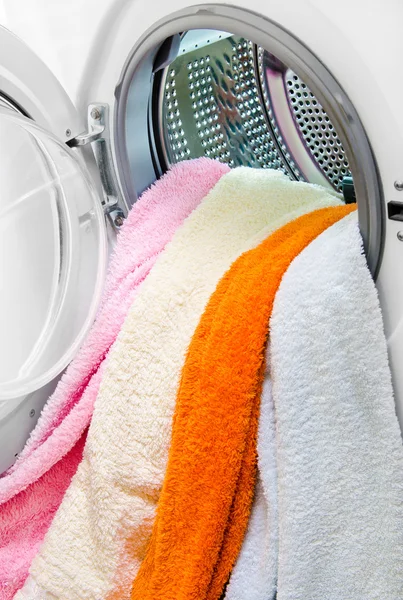 Woman taking color clothes from washing machine — Stock Photo, Image