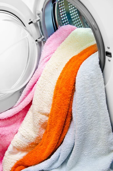 Woman taking color clothes from washing machine — Stock Photo, Image