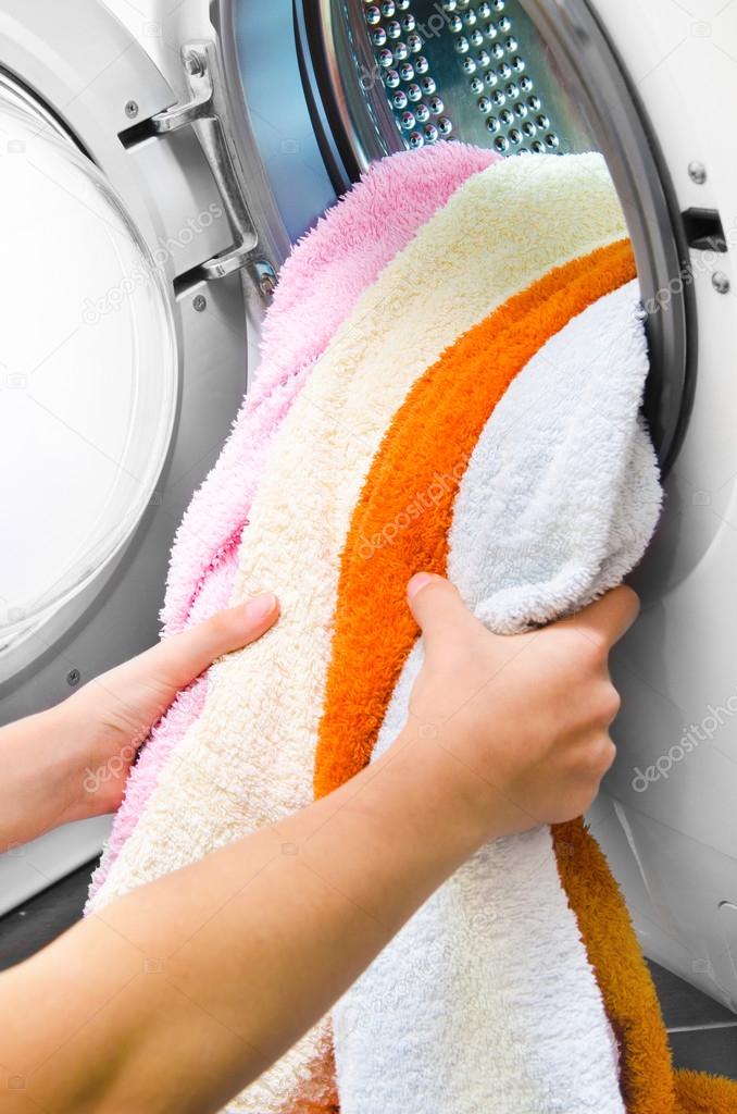 Woman taking color clothes from washing machine