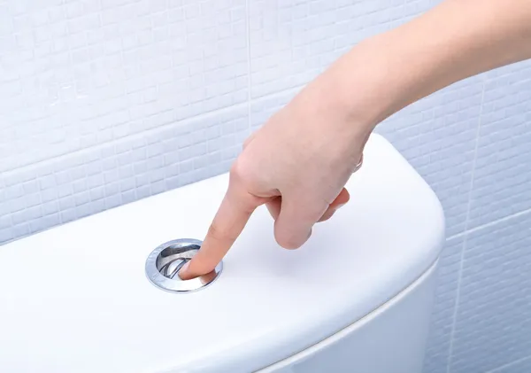 Finger pushing button and flushing toilet Stock Picture