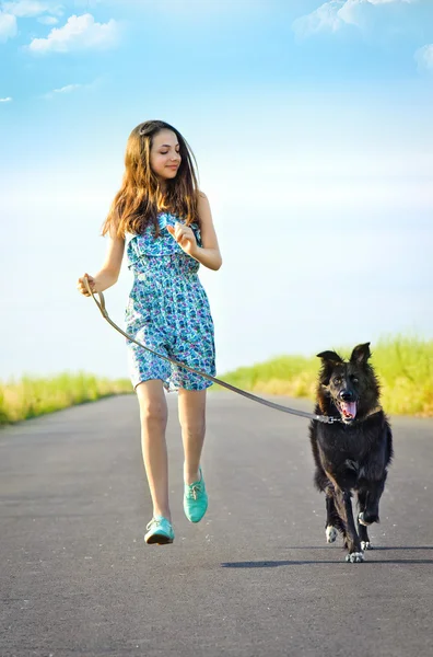 Tjej med en hund på en promenad — Stockfoto