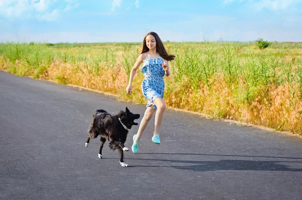 Tjej med en hund på en promenad — Stockfoto