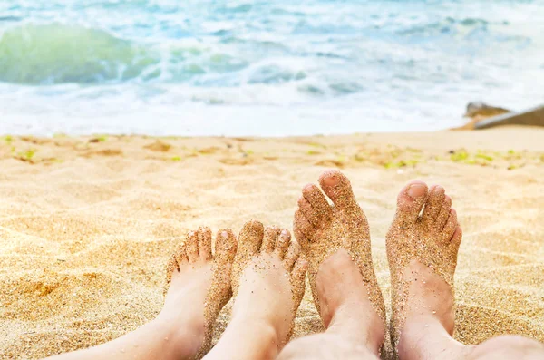 Giovane ragazza e uomo gambe in mare — Foto Stock