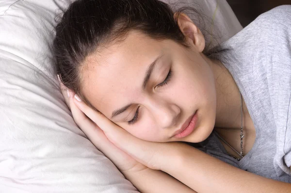 Fiatal lány az ágyban alszik — Stock Fotó