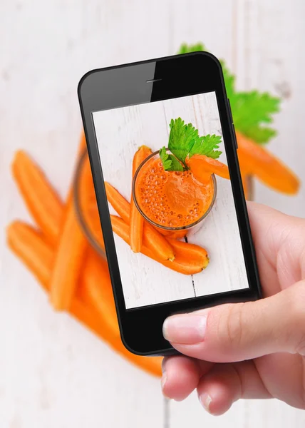 Händer med foto färsk juice med smartphone — Stockfoto