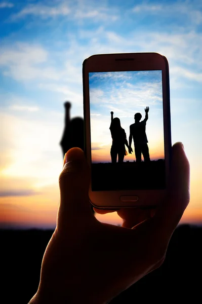 Manos tomando fotos pareja joven enamorada de teléfono inteligente —  Fotos de Stock