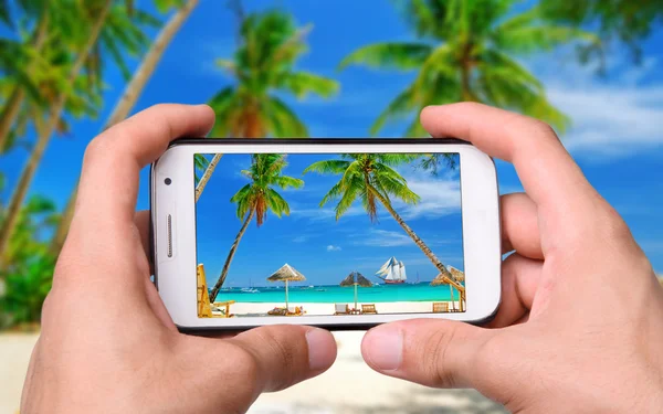 Mãos tirando foto praia com smartphone — Fotografia de Stock