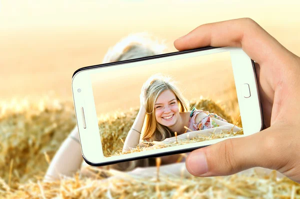 Mãos tirando foto jovem posando ao ar livre com smartphone — Fotografia de Stock