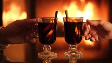 Genç çift şömine arkasında sıcak şarap eşliğinde romantik bir akşam yemeği yiyor. Romantik konsept.