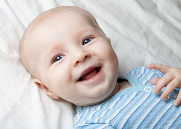 Smiling baby on the sheet — Stock Photo, Image