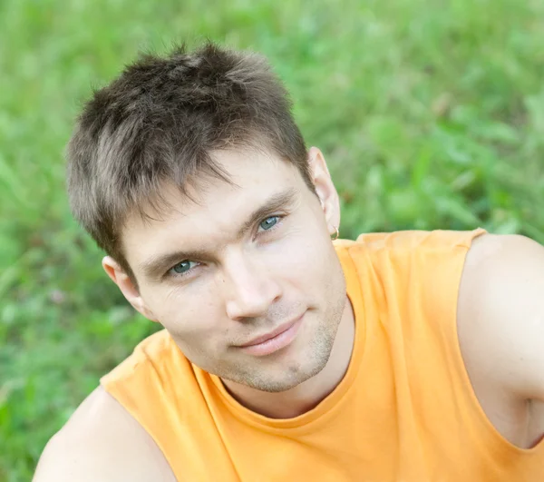 Face portrait of man sitting on a grass — Stock Photo, Image