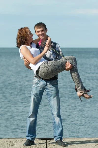 Man houdt zijn vrouw op handen buitenshuis — Stockfoto