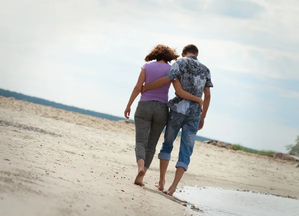 Man en vrouw lopen in de buurt van de zee — Stockfoto