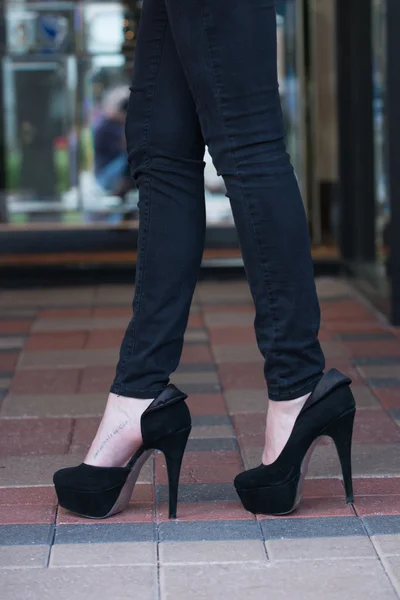 Tacones altos negros en bloque de pavimentadora — Foto de Stock