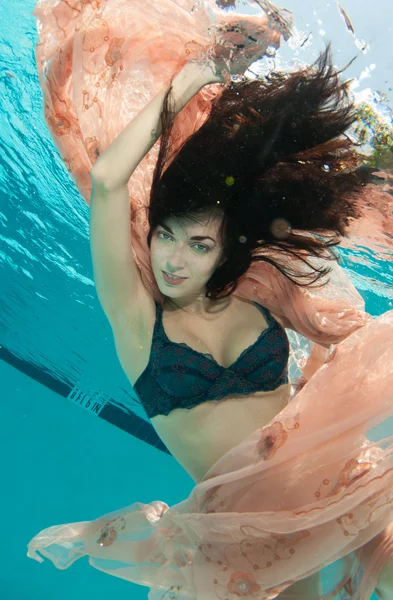 Model uśmiechający się pływanie pod wodą — Zdjęcie stockowe
