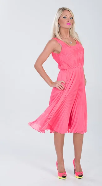 Blonde haired model in frilly pink dress Stock Photo