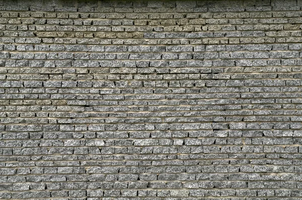 Стена из гранитного кирпича — стоковое фото