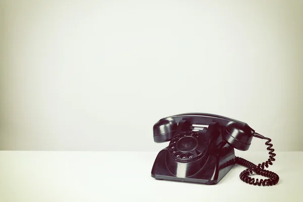 Vintage zwarte telefoon met grijze achtergrond — Stockfoto