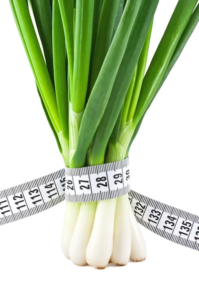 Measuring tape wrapped around a green onions — Stock Photo, Image