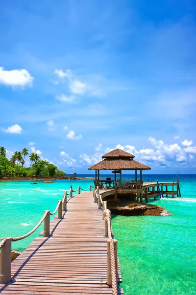 Mare con molo sotto cielo azzurro nuvoloso — Foto Stock