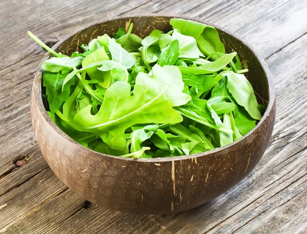 Resh arugula salad on wooden table — Stock Photo, Image